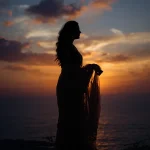 An Indian Woman's Elegant Silhouette Against a Setting Sun | cinematic saree ai prompt